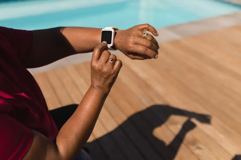senior woman using smartwatch next to the swimming 2023 11 27 05 30 40 utc