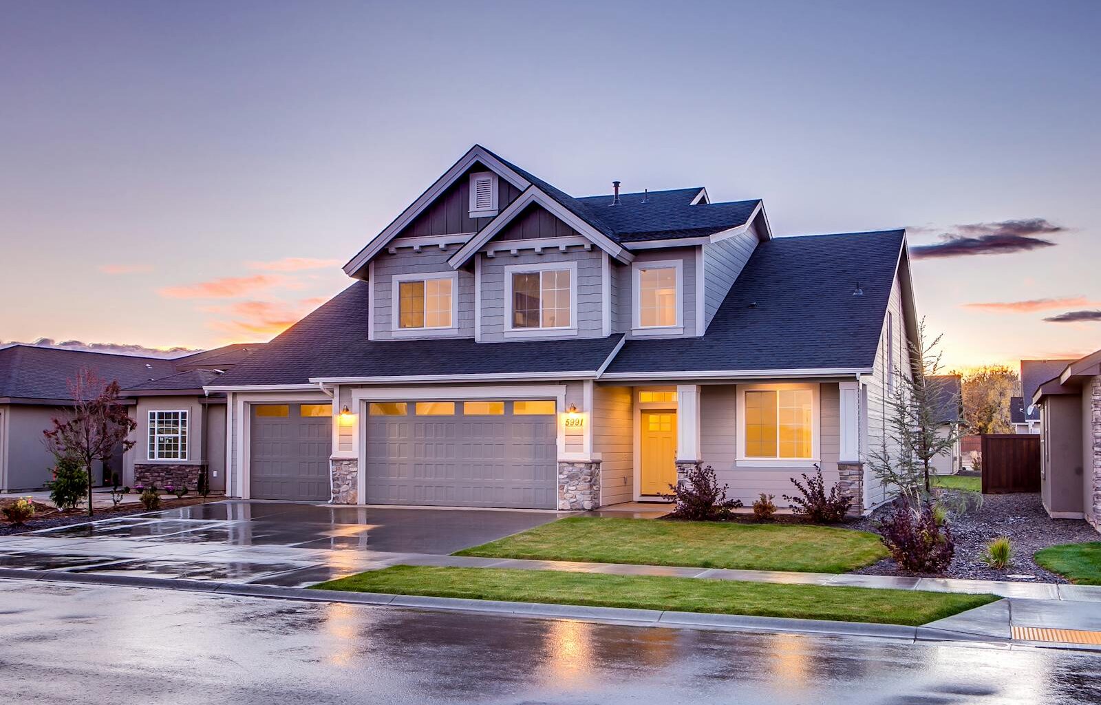 Elegant suburban home with driveway at sunset showcasing modern architecture.