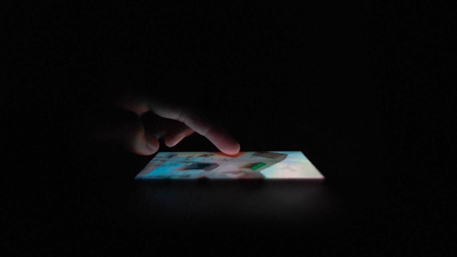Dłonie trzymające telefon z powiadomieniem o wiadomości w ciemnym pokoju
