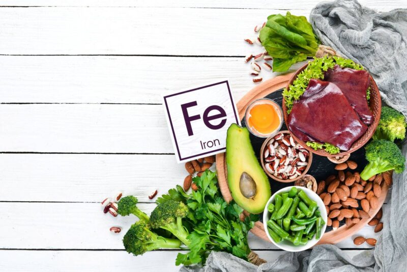 food containing natural iron fe liver avocado broccoli spinach parsley beans nuts white wooden background top view wp