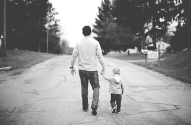 man holding baby's hand