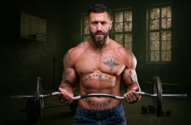 Mężczyzna ćwiczy uginanie ramion ze sztangą na siłowni